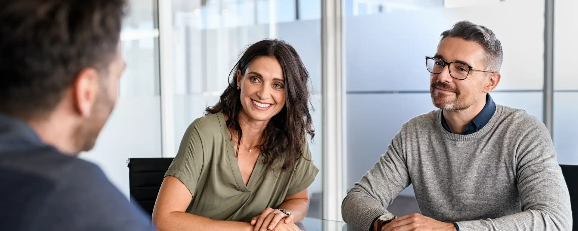 Eine Frau und ein Mann im Gespräch mit einem Berater