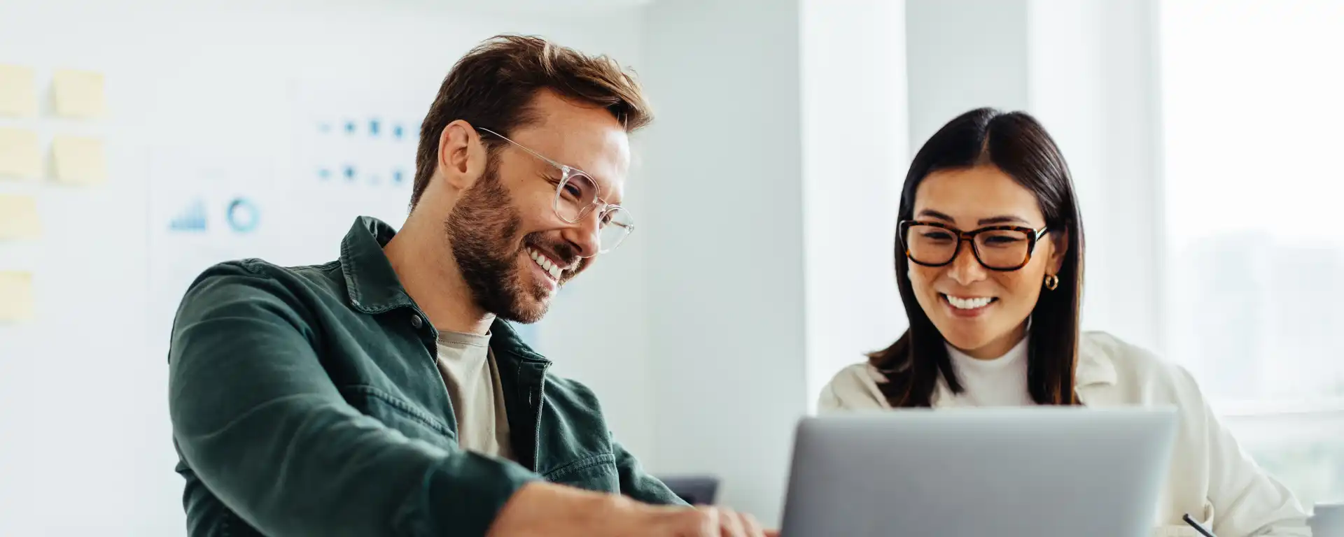 Ein Mann und eine Frau sitzen vor einem Laptop