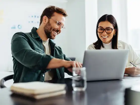 Ein Mann und eine Frau sitzen vor einem Laptop